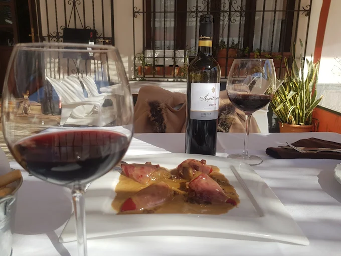 Mesa con comida y dos copas de Vino Azpilicueta